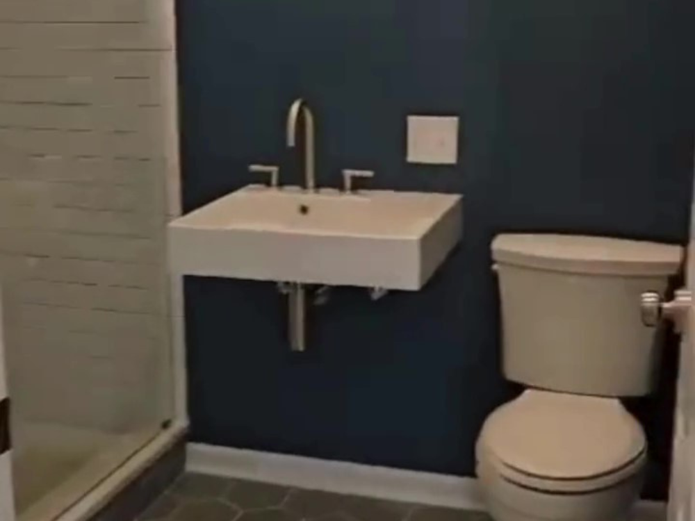 Spotless bathroom after a professional bathroom and empty rooms cleaning, featuring a clean toilet, sink, and glass shower.