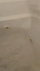 Bathtub deep cleaning showing dirt and residue before cleaning