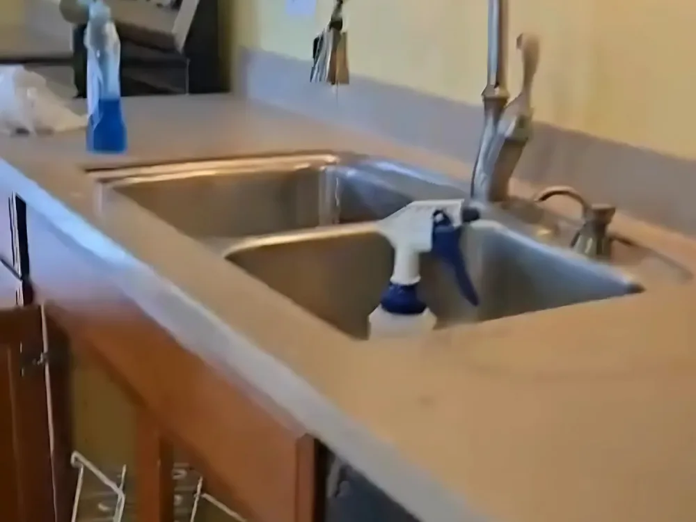 Kitchen and living room cleaning showing a well-maintained countertop and sink area.