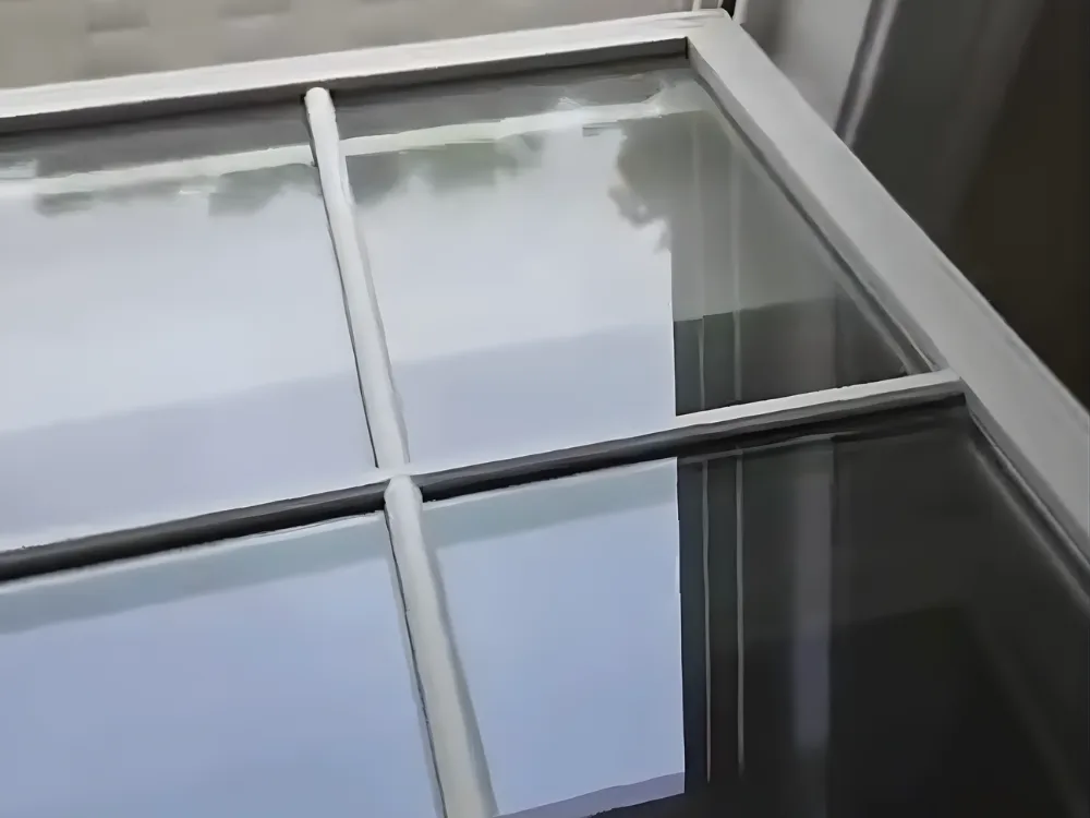 Window cleaning process viewed from inside showing open window and outdoor work.