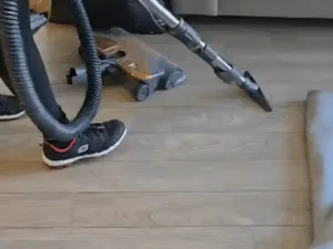 Deep kitchen cleaning showing vacuuming of the floor area.