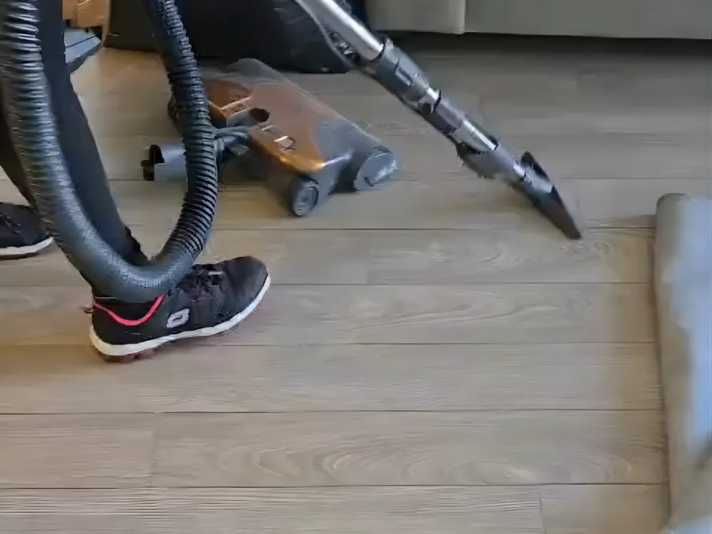 Deep kitchen cleaning showing vacuuming of the floor area.