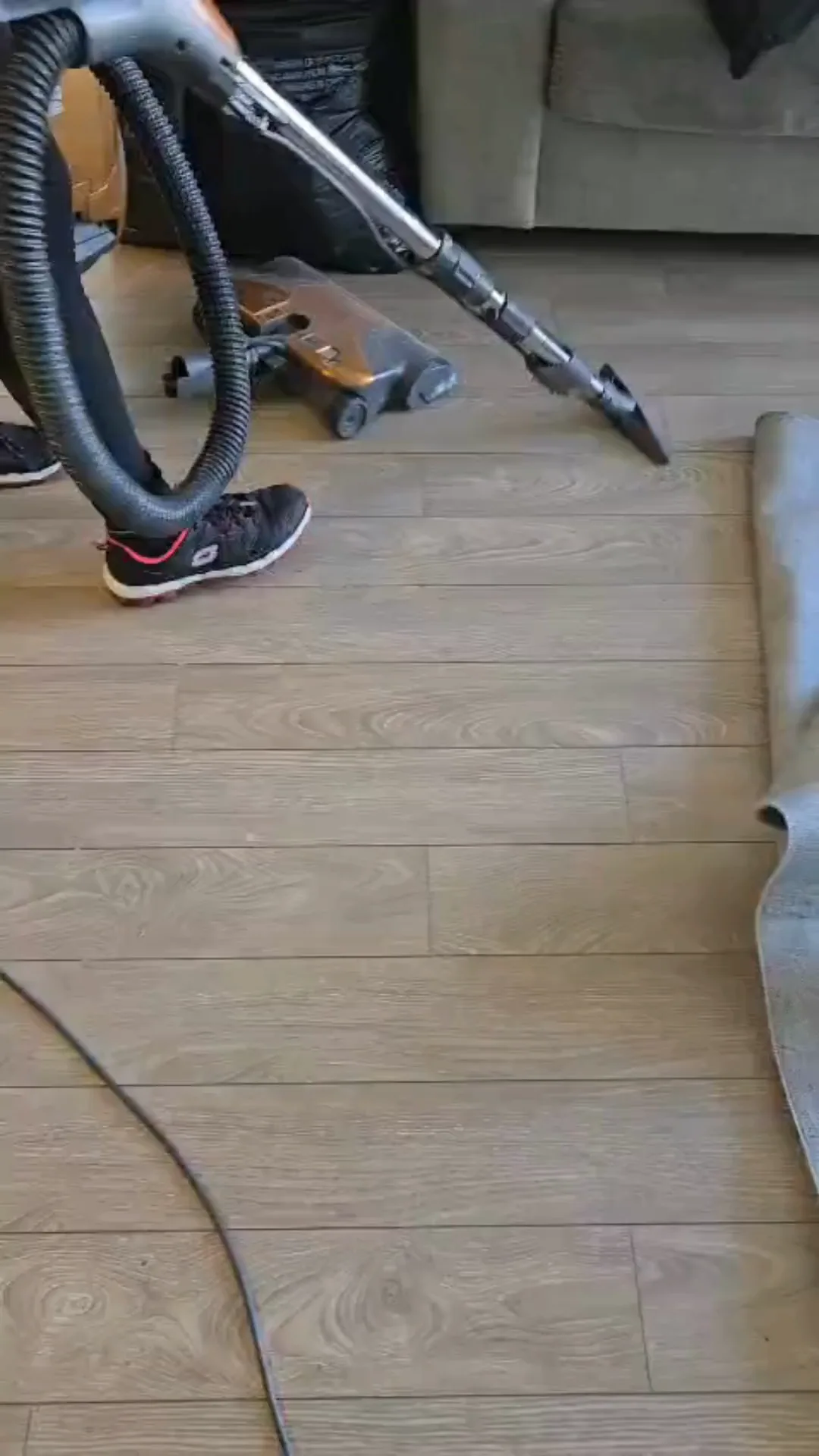 Deep kitchen cleaning with vacuum equipment and partially lifted carpet.