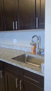 Deep kitchen cleaning showing polished granite countertop and sink area.