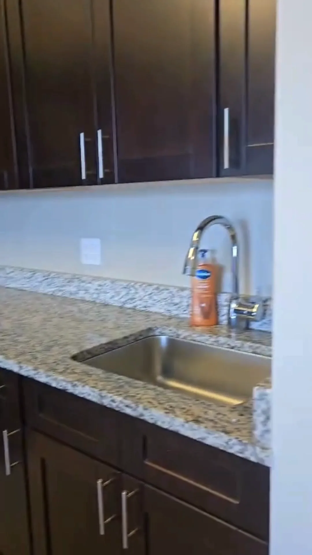 Deep kitchen cleaning showing polished granite countertop and sink area.