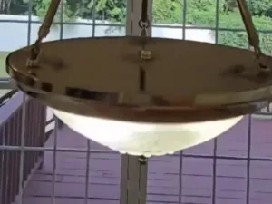 A clear, glowing glass and brass fixture successfully restored after deep chandelier cleaning.