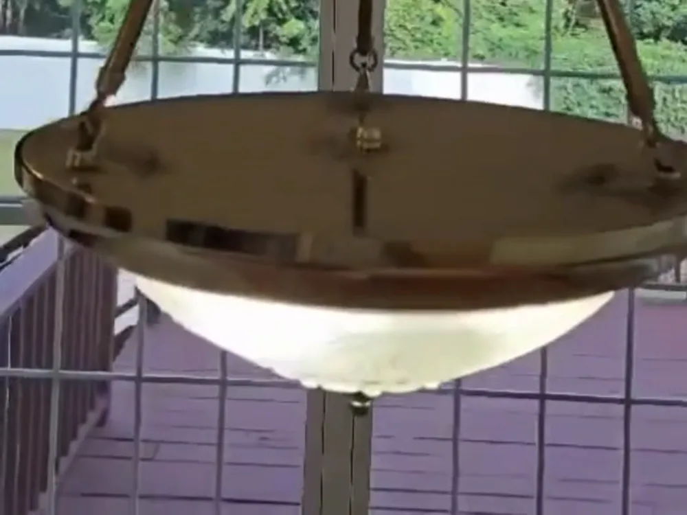 A clear, glowing glass and brass fixture successfully restored after deep chandelier cleaning.
